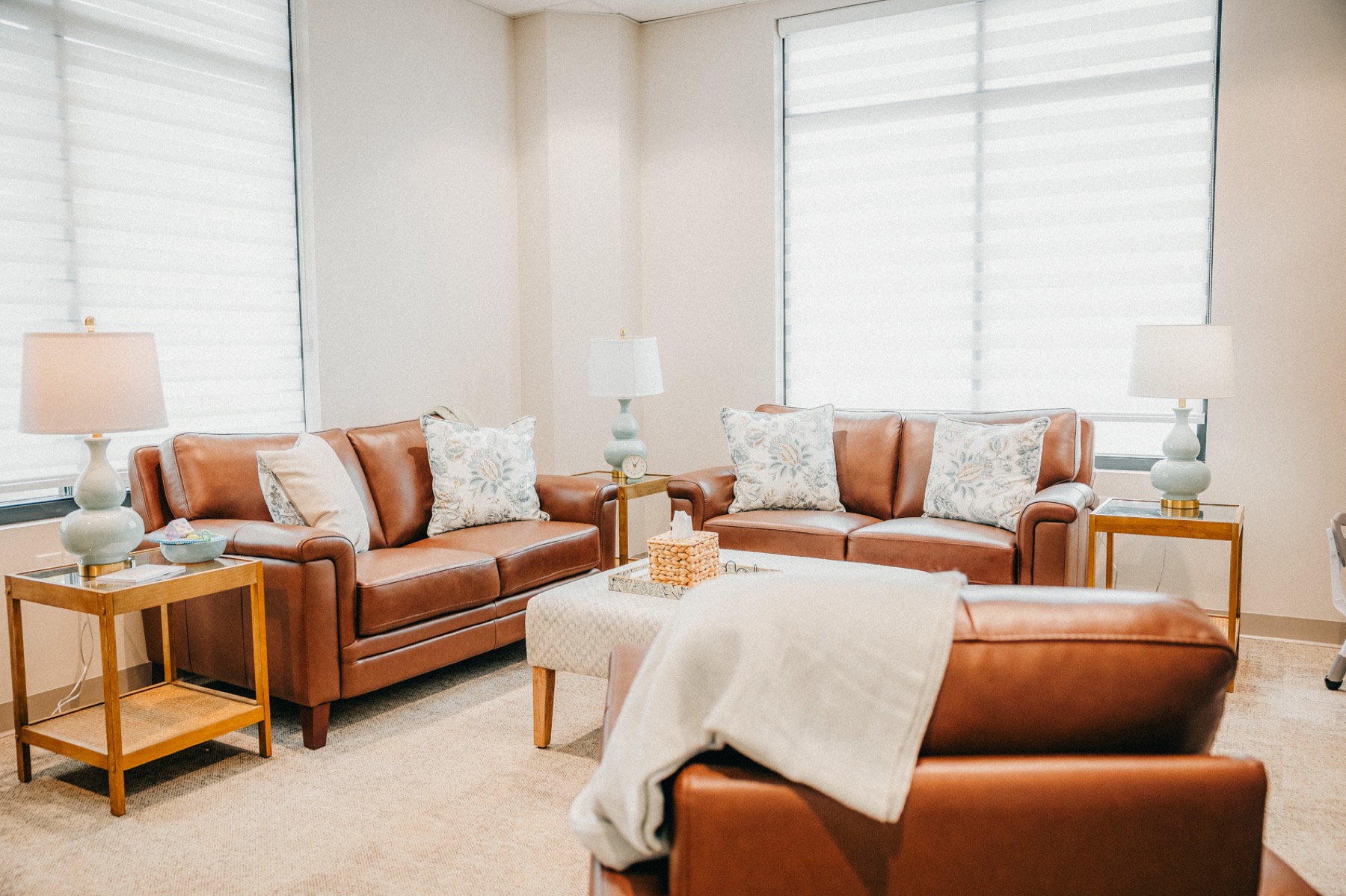 A counseling room with leather sofas and soft window light