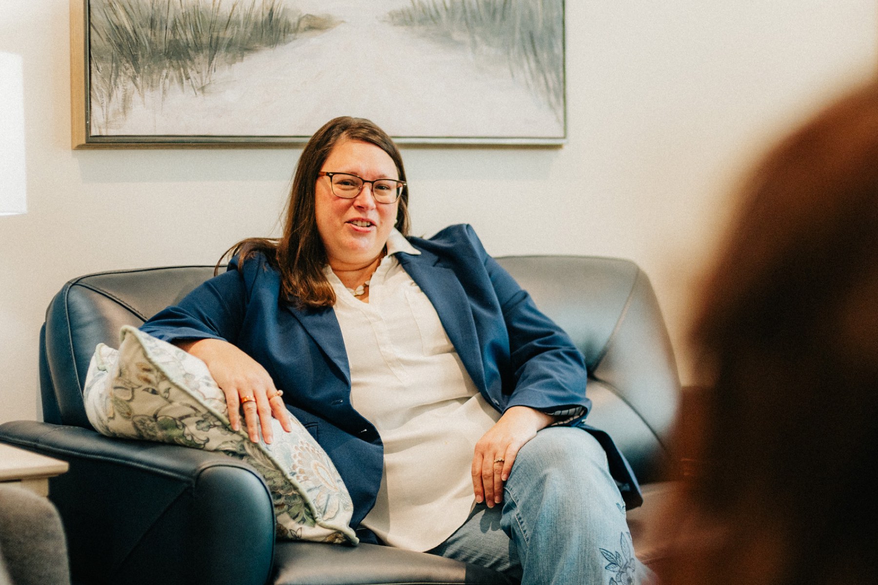 A provider listening from a leather sofa in her counseling room
