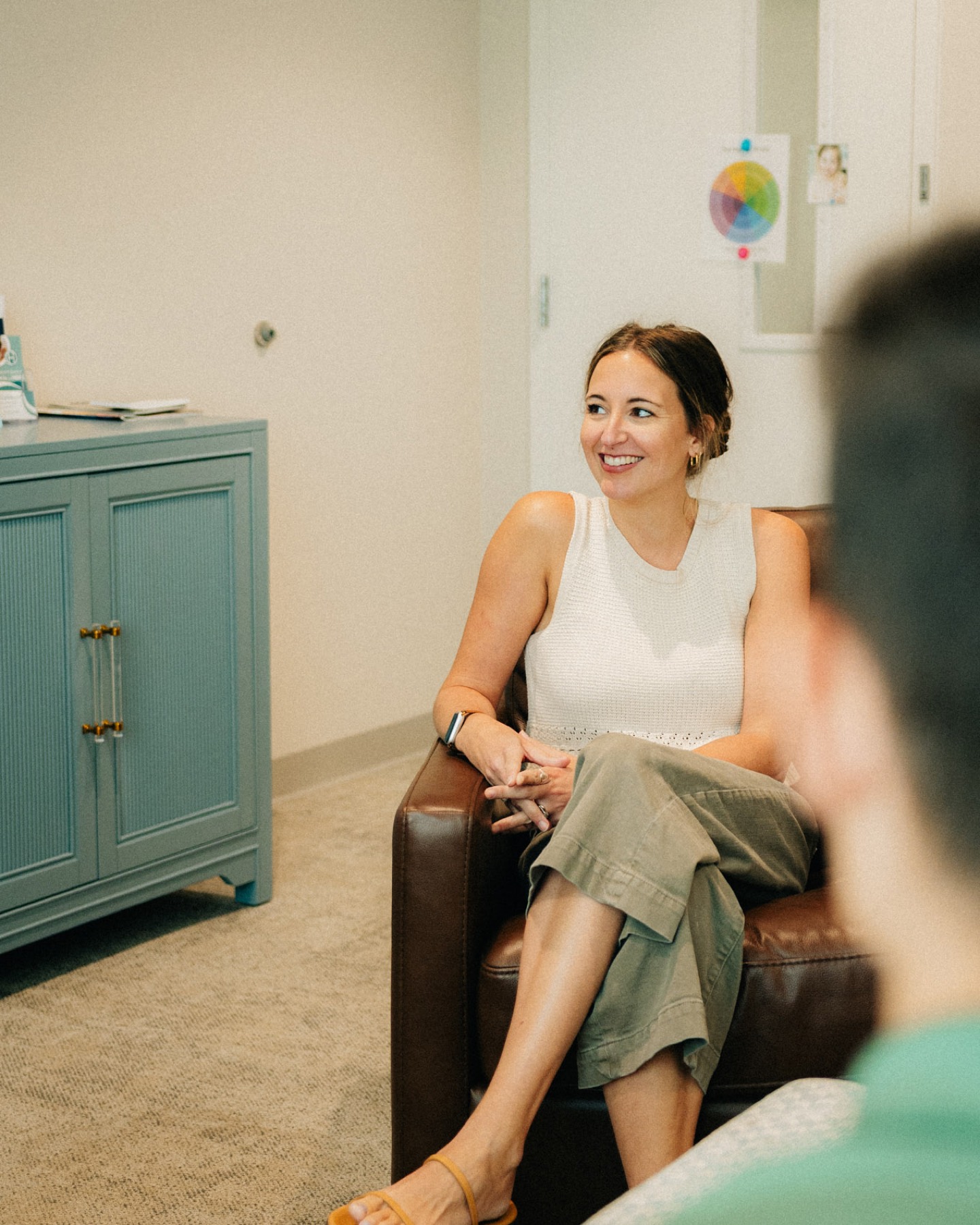 A provider listening from an armchair in her counseling room